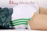 Watching our sexy archive girl wearing a sexy white shiny nylon shorts and a green rainjacket (Pics)