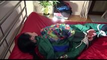 Lucy tied and gagged on a bed with red shiny nylon cloth wearing supersexy green rainwear (Video)