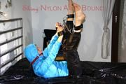 Pia tied, gagged and hooded on a bed wearing a sexy black shiny nylon rian pants and a ice blue down jacket (Pics)