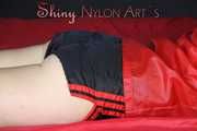 Watching sexy SONJA wearing a sexy black shiny nylon shorts and a red rainjacket preparing her lolling area (Pics)