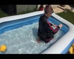 Mara wearing a shiny black/pink adidas training suit playing with water in the pool (Video)