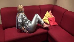 Sophie tied and gagged on the sofa wearing a shiny silver PVC sauna suit (Video)