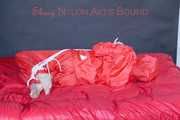 Destiny wearing a sexy red rain suit tied and gagged and hooded with ropes and a cloth gag on a bed (Pics)