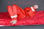 Destiny wearing a sexy red rain suit tied and gagged and hooded with ropes and a cloth gag on a bed (Pics)