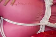 Lucy tied and gagged on a sofa wearing a pink shiny nylon skibib (Pics)
