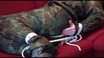 Jill tied, gagged and hooded on a red sofa wearing sexy shiny nylon camouflage rainwear (Video)