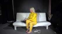 Watching Pia preparing her sofa with a shiny nylon cloth wearing a yellow shiny nylon rainsuit enjoying herslef on the sofa (Video)