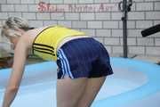 Sexy Sonja wearing a darkblue shiny nylon shorts and a yellow top enjoying the water in the swimming pool (Pics)