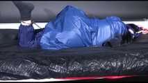 Lucy ties and gagges herself with cuffs on a bed wearing sexy blue shiny nylon rainwear (Video)