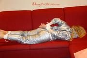 Sophie tied and gagged on the sofa wearing a shiny silver PVC sauna suit (Pics)