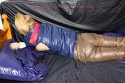 Samantha tied and gagged on bed wearing a brown shiny nylon downpanst and a blue downjacket (Pics)