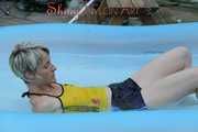 Sexy Sonja wearing a darkblue shiny nylon shorts and a yellow top enjoying the water in the swimming pool (Pics)