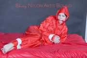 Destiny wearing a sexy red rain suit tied and gagged and hooded with ropes and a cloth gag on a bed (Pics)