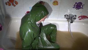 Mara ties, gagges and hoodes herself in a bath tub with muddy water wearing a sexy rainwear jumpsuit with hood (Video)