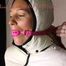 Watching sexy Sandra wearing a sexy pink shiny nylon rainpants and a special white down jacket being tied and gagged and hooded with ropes and a ballgag on a bar (Pics)