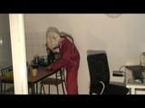 Blonde-haired archive girl being at home wearing shiny nylon rainwear (Video)