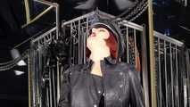 Mistress Tokyo smoking cigarette in leather, gloves and Muir Cap; fetish, POV