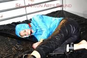 Pia tied, gagged and hooded on a bed wearing a sexy black shiny nylon rian pants and a ice blue down jacket (Pics)