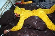 Stella tied and gagged in a shiny yellow rainsuit