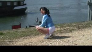 Stella on a lake wearing shiny nylon shorts and rain jacket (Video)