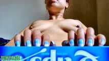 Blue and white nail tapping topless on a thin cardboard box