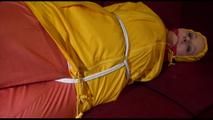 Lucy tied, gagged and hooded on a red sofa wearing a sexy orange shiny nylon pants and a yellow rain jacket (Video)